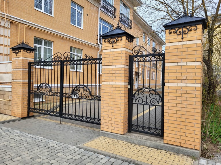 Beautiful wrought iron carved gates between brick columns